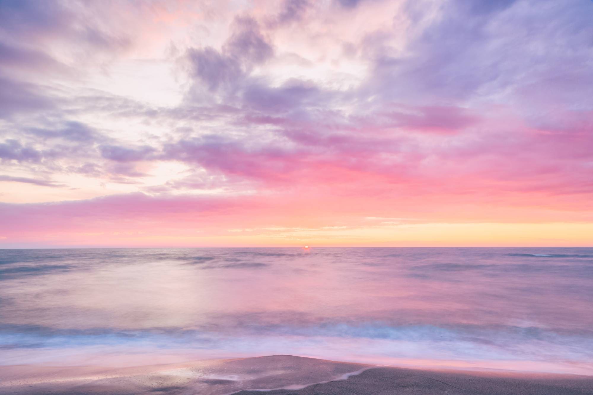 A pink and purple sky over the ocean.