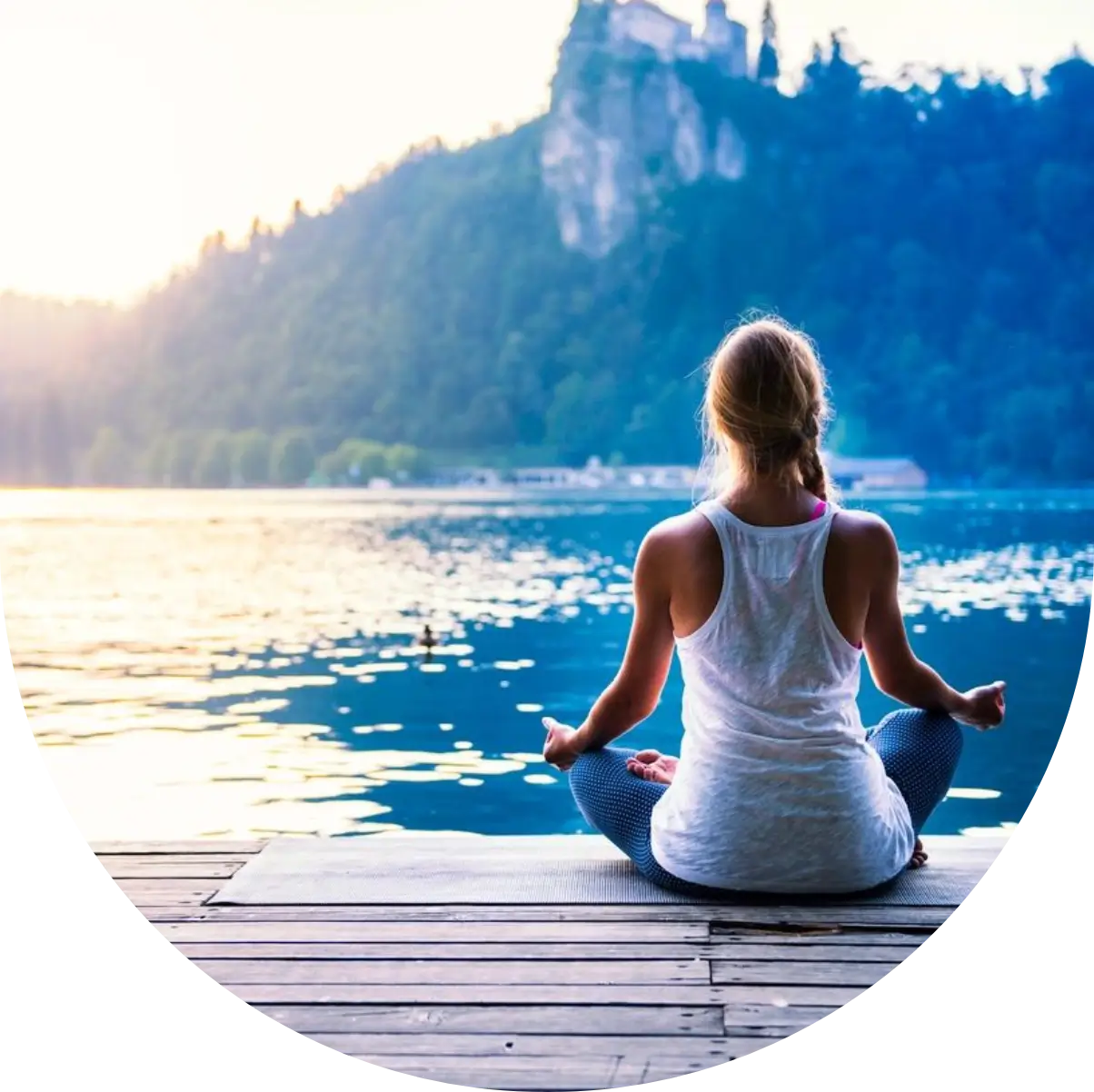 A woman sitting on the dock of a lake