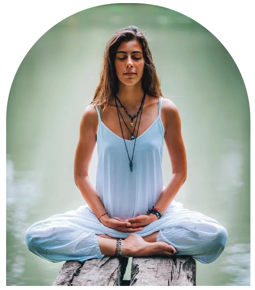 A woman sitting in the lotus position with her hands folded on her knees.