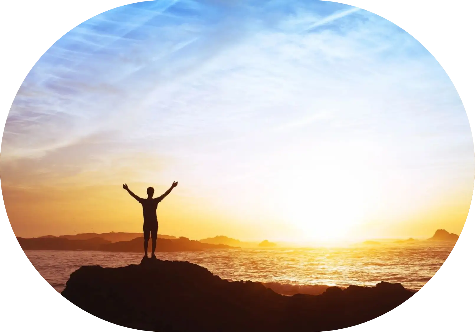 A person standing on top of a rock near the ocean.