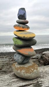 Colorful stacked stones on a beach.