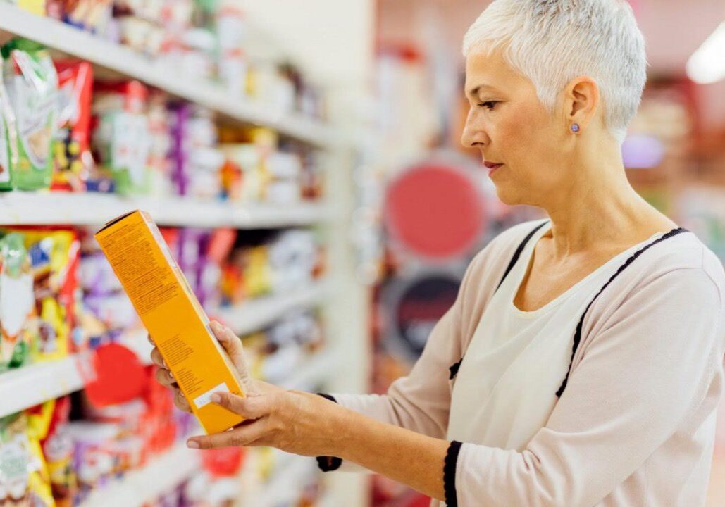 Woman shopping in a grocery store aisle.
